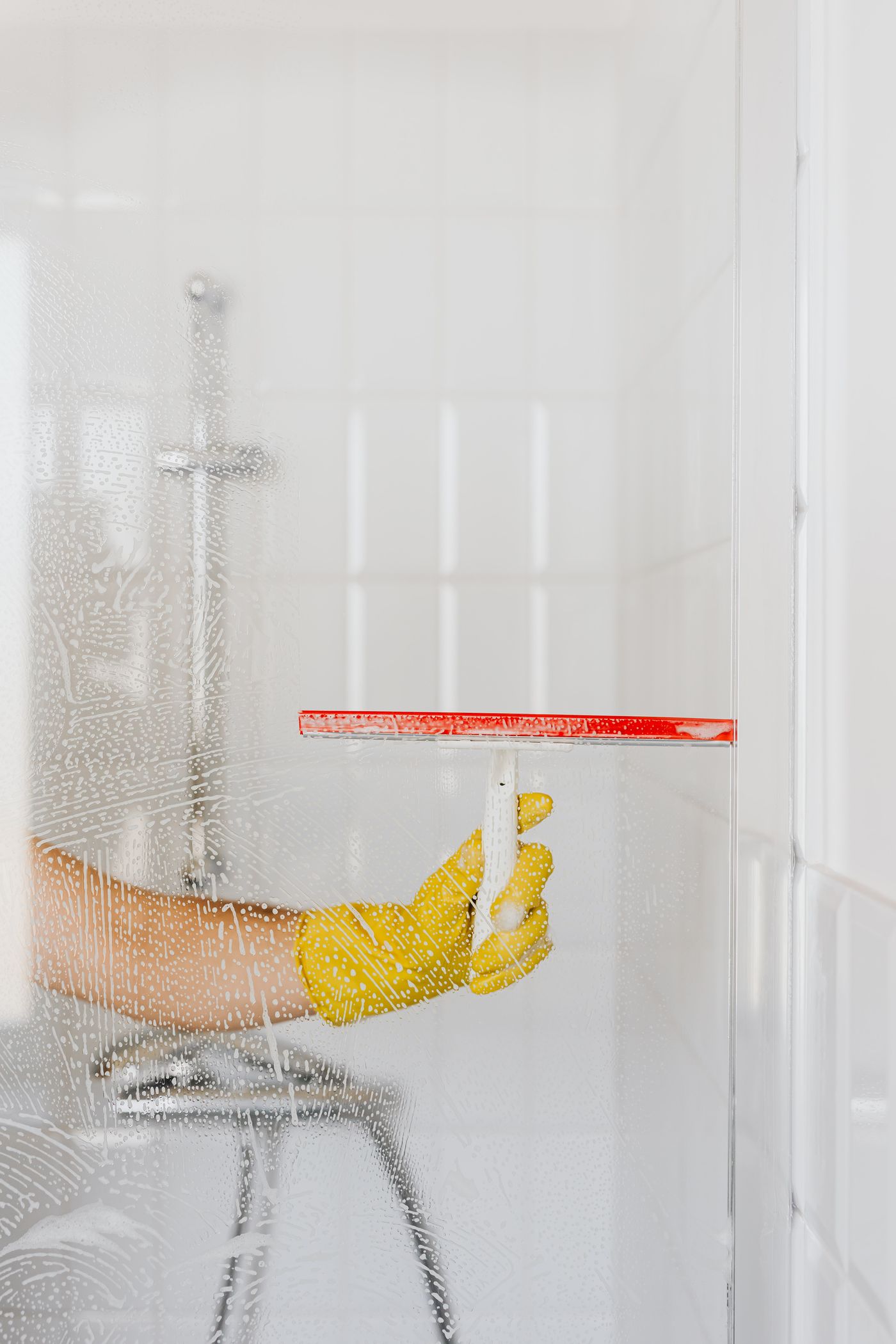Squeegee clearing a shower glass, Pexels.