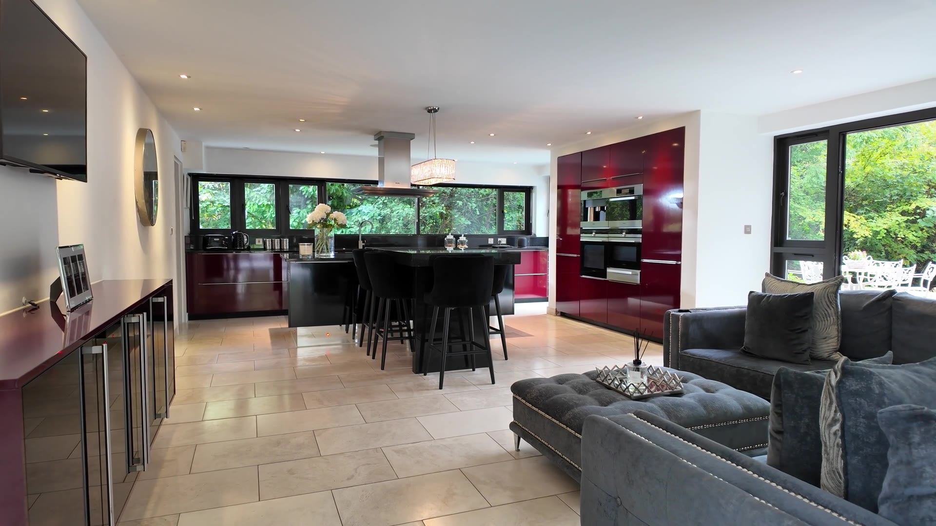 Stock kitchen: burgundy cabinets, black island, light stone floor. Pexels, not a Gallegos job.