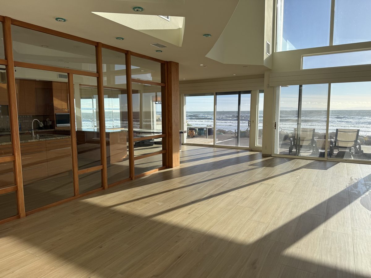 An oceanfront great room floored wall to wall in wood-look porcelain plank.